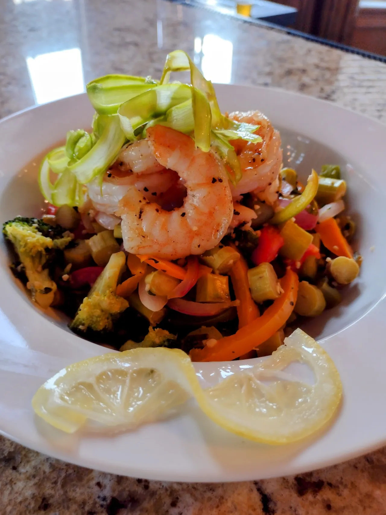 Shrimp over sauteed vegetables with lemon