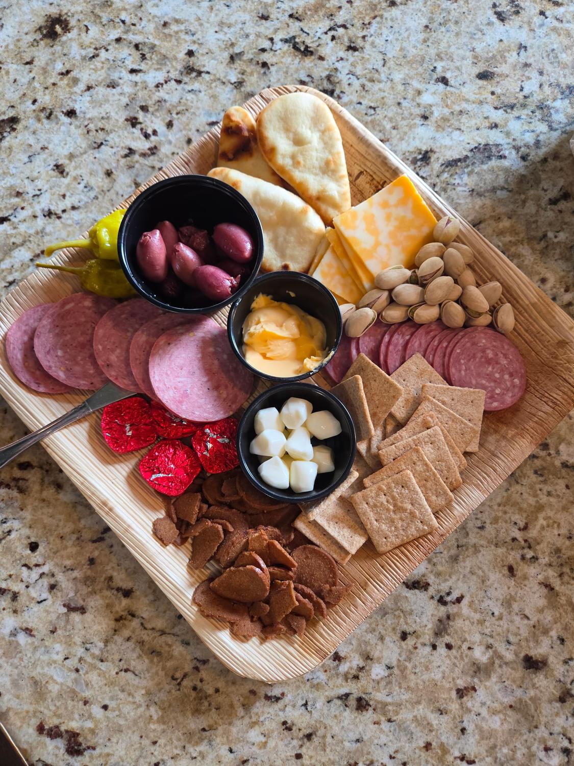 A charcuterie board with meats, cheeses, and naan